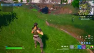 Green skeleton ESP tags two distant enemies with distances across a grassy field near a bridge — Arcane Fortnite cheat