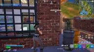Green skeleton ESP revealing an enemy behind a brick wall beside an aimbot FOV circle — Arcane Fortnite cheat